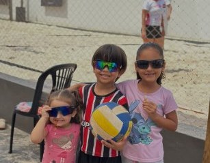 Crianças com a bola de vôlei na arena